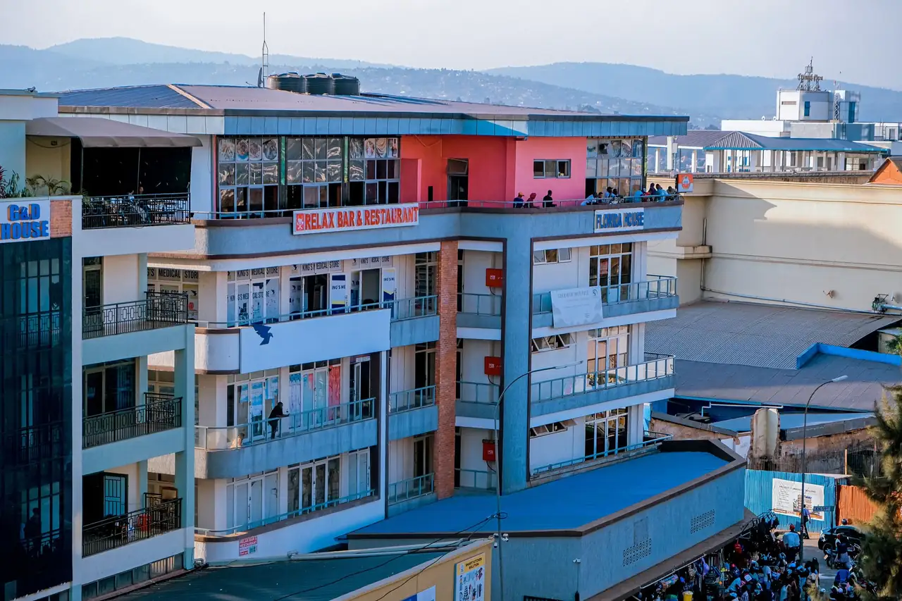 Aerial view of a modern urban building featuring a rooftop restaurant in Kigali, Rwanda.